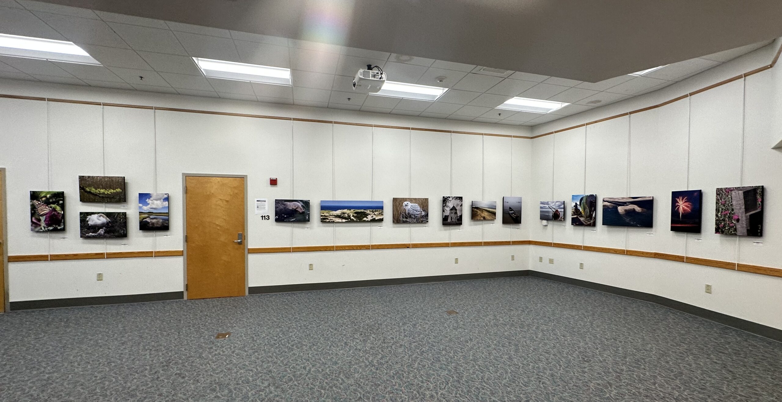 Art hung on a wall around a space in the visitor center.